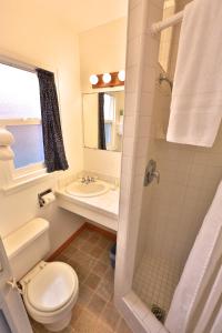 y baño con aseo, lavabo y ducha. en Pleasant Inn, en Morro Bay