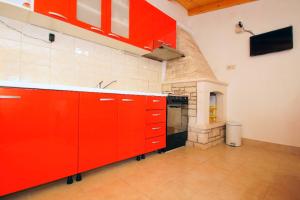 kuchnia z czerwonymi szafkami i kuchenką w pokoju w obiekcie Getaway Beach House w mieście Vela Luka