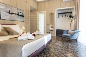 une chambre d'hôtel avec un lit et une chaise dans l'établissement B&B Palazzo Perrotta, à Catane