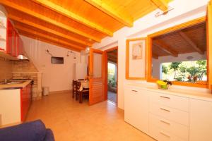 uma cozinha com armários brancos e uma mesa em Getaway Beach House em Vela Luka