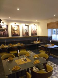 ein Esszimmer mit Tischen und gelben Stühlen in der Unterkunft Hotel Landgasthof Adler in Bad Krozingen