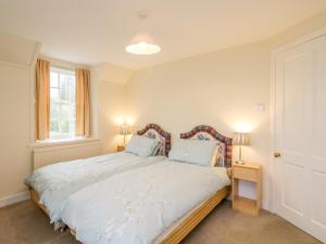 a bedroom with a large bed with two lamps at Stable Flat in New Scone