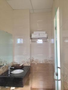 y baño con lavabo y ducha. en Lavender Hotel en Ðồng Hới