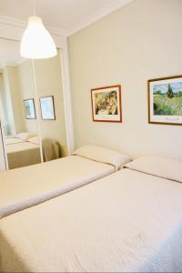 Pokój z 3 łóżkami i lustrem w obiekcie Chez Elo's Marbella Milla de Oro. Jardin Privado w Marbelli