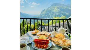 a table with plates of food on top of a balcony at Paraiso Guest House in Ella