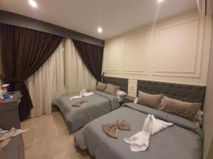 two beds in a hotel room with towels on them at City Palace Hotel in Cairo