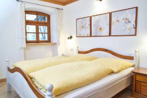 ein Schlafzimmer mit einem Bett mit gelber Bettwäsche und einem Fenster in der Unterkunft Ferienpension Posthof in Waldmünchen