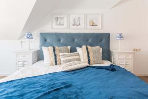 - un grand lit avec une tête de lit et des oreillers bleus dans l'établissement TURMHAUS Whg. TH-15, à Wustrow