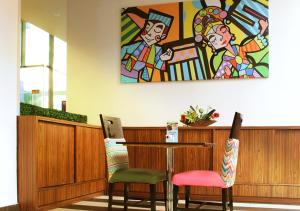 a table with two chairs and a painting on the wall at MaxOneHotels.com at Sabang in Jakarta