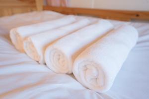 a group of white towels sitting on top of a bed at Hostel Chapter Two Tokyo in Tokyo