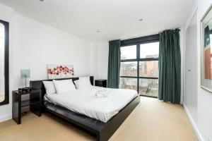 a bedroom with a bed and a large window at Superfast Broadband 2BD City Flat Farringdon in London