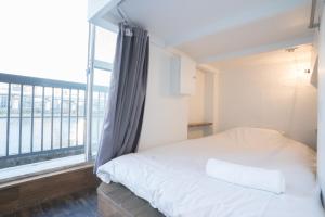 a bedroom with a bed and a large window at Hostel Chapter Two Tokyo in Tokyo