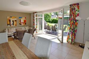 a living room with a table and chairs and a patio at Haus STRANDHAFER WF-07 (rechts) in Wustrow