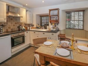 a kitchen with a wooden table with plates on it at Barney's Cottage in Ambleside