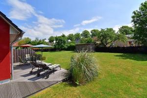 a patio with a table and chairs on a yard at Haus STRANDHAFER WF-07 (rechts) in Wustrow