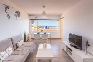 salon z kanapą, telewizorem i stołem w obiekcie APARTAMENTO PRIMERA LINEA w mieście Mojácar