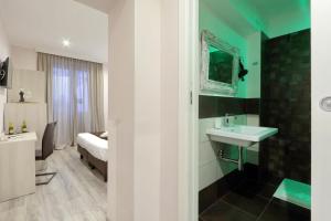 a bathroom with a sink and a bed in a room at Roma Suite Monti in Rome