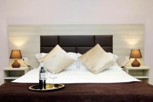a bedroom with a large bed with a bottle of wine at Roma Suite Monti in Rome