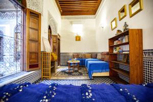 ein Zimmer mit einem blauen Bett und einem Tisch in der Unterkunft Dar Settash in Fès