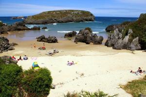 a group of people on a beach near the ocean at DavidSara in Llanes