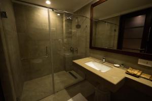 a bathroom with a shower and a sink and a mirror at Sea Shell Neil in Neil Island