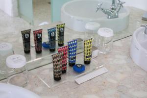 a bathroom counter with a sink and a bunch of test tubes at Hôtel De Sers Champs Elysées Paris in Paris