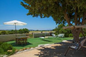 a patio with a table and an umbrella at B&B Isole Dello Stagnone in Birgi Vecchi