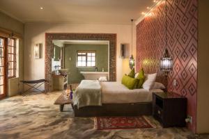 a bedroom with a large bed and a bath tub at Singa Lodge - Lion Roars Hotels & Lodges in Port Elizabeth