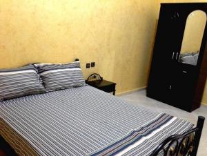 a bedroom with a bed with a black dresser and a mirror at Silia Appartements in Temara