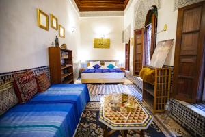 ein Wohnzimmer mit Sofa und Bett in der Unterkunft Dar Settash in Fès
