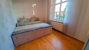 a small bedroom with a bed in a room with a window at Ferienwohnung Pasewalk in Papendorf