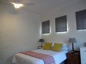 a bedroom with a white bed with green pillows at 273 Rhino retreat-solar backup in Centurion