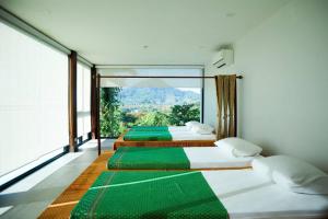 two beds in a room with a large window at Andakiri Pool Villa Panoramic Sea View - SHA Certified in Ao Nang Beach