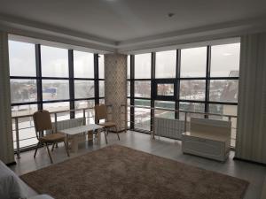 a room with a table and chairs and windows at Турист in Taraz