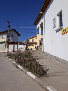 a building with a fence in front of a street at Hotel Toni in Bukovlŭk
