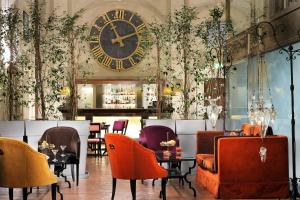 un restaurante con un reloj grande en la pared en Grand Hotel Continental Siena - Starhotels Collezione, en Siena