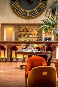 a restaurant with a table and a large clock on the wall at Grand Hotel Continental Siena - Starhotels Collezione in Siena