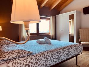 1 dormitorio con 1 cama con lámpara. en Mortirolo, en Mazzo di Valtellina