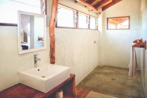a bathroom with a sink and a mirror at Musica do Mar Beach Front Apartments, Ocean View in Praia do Tofo