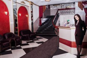 a woman standing at a bar in a room with a staircase at Hotel Dauria in Chita