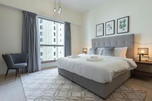 a bedroom with a large bed and a desk and a chair at GuestReady - Infinite Dreams in Dubai