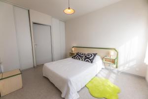 1 dormitorio con cama y alfombra amarilla en Sphinx Résidences - Les Germes de Blé en Épron