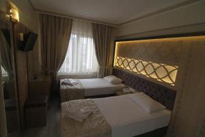 Postel nebo postele na pokoji v ubytování Grand Liza Hotel