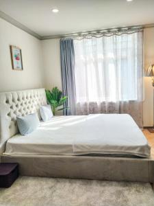 a bedroom with a large white bed with a window at Old Tbilisi Apartments in Tbilisi City