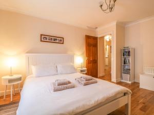 a bedroom with a large white bed with two pillows at Siskin in Keswick