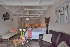 a bedroom with a bed and a couch and a table at De Witte Huis in Bethlehem