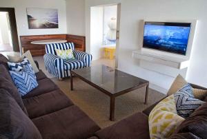 a living room with a couch and a tv at Rockshandy Beachhouse in Southbroom