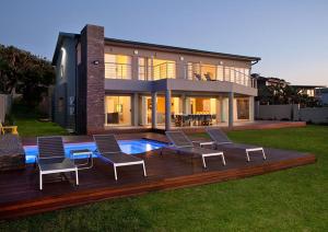 a house with a deck with chairs and a pool at Rockshandy Beachhouse in Southbroom