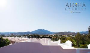 a large building with a mountain range at Aloha Gardens by Vacation Care in Marbella
