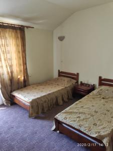 1 dormitorio con 2 camas y ventana en Hotel Turist Beharca, en Beharca